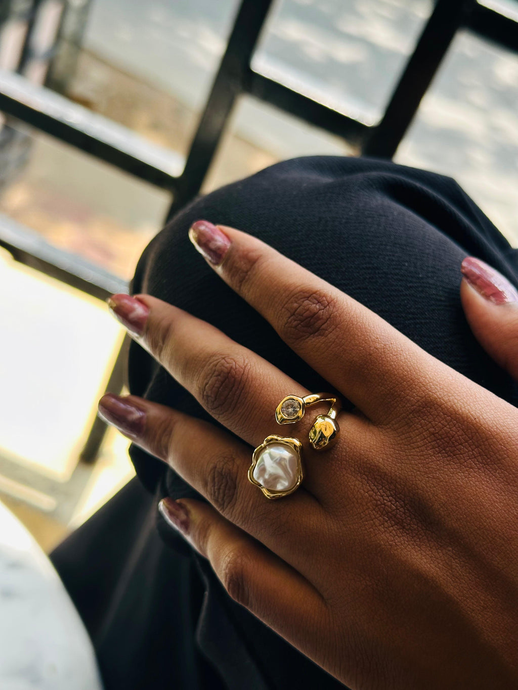 Gold baroque pearl open ring worn on Indian woman's finger close up