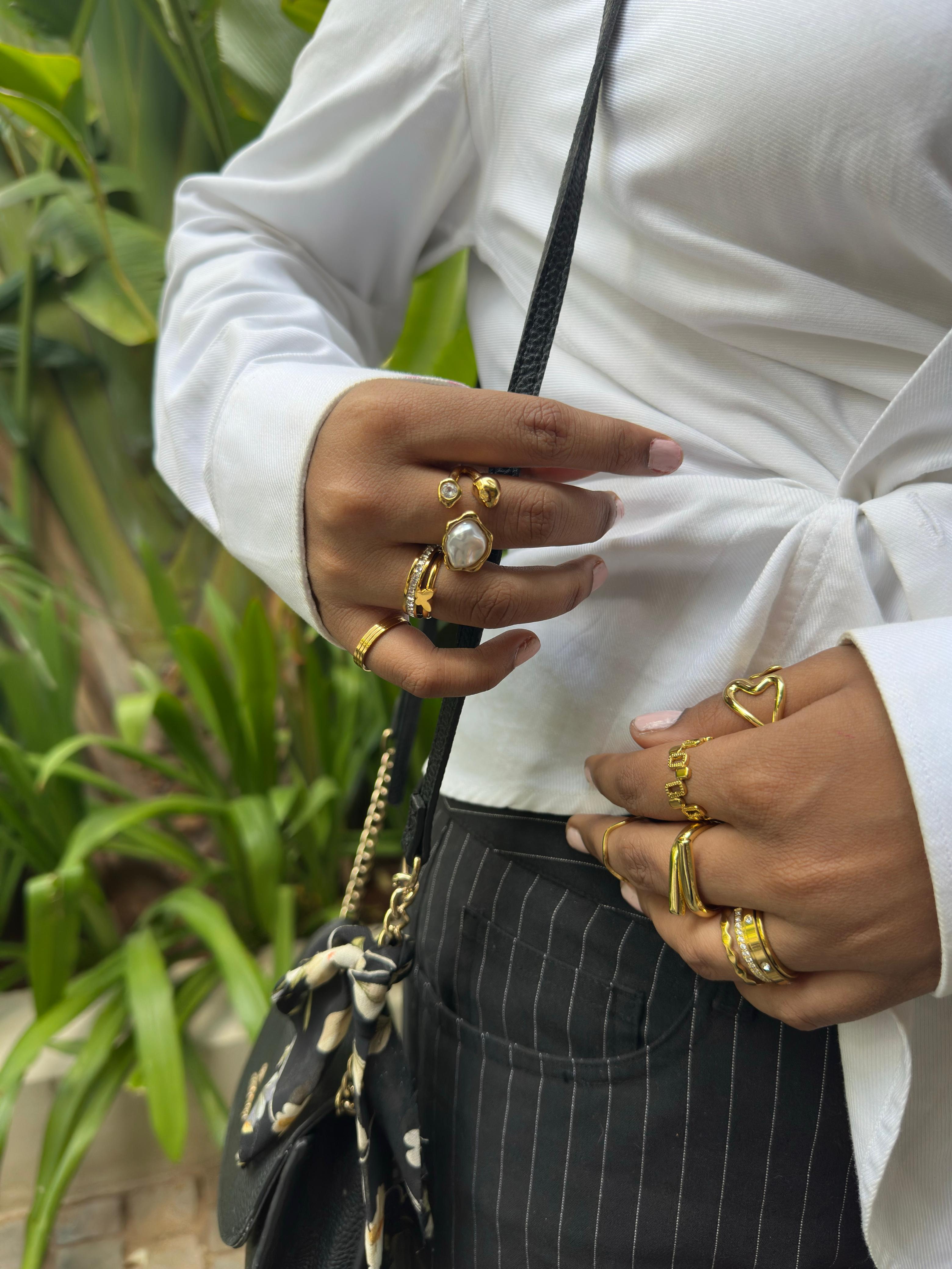 Gold baroque pearl open ring worn stacked with other gold rings on Indian woman's hand