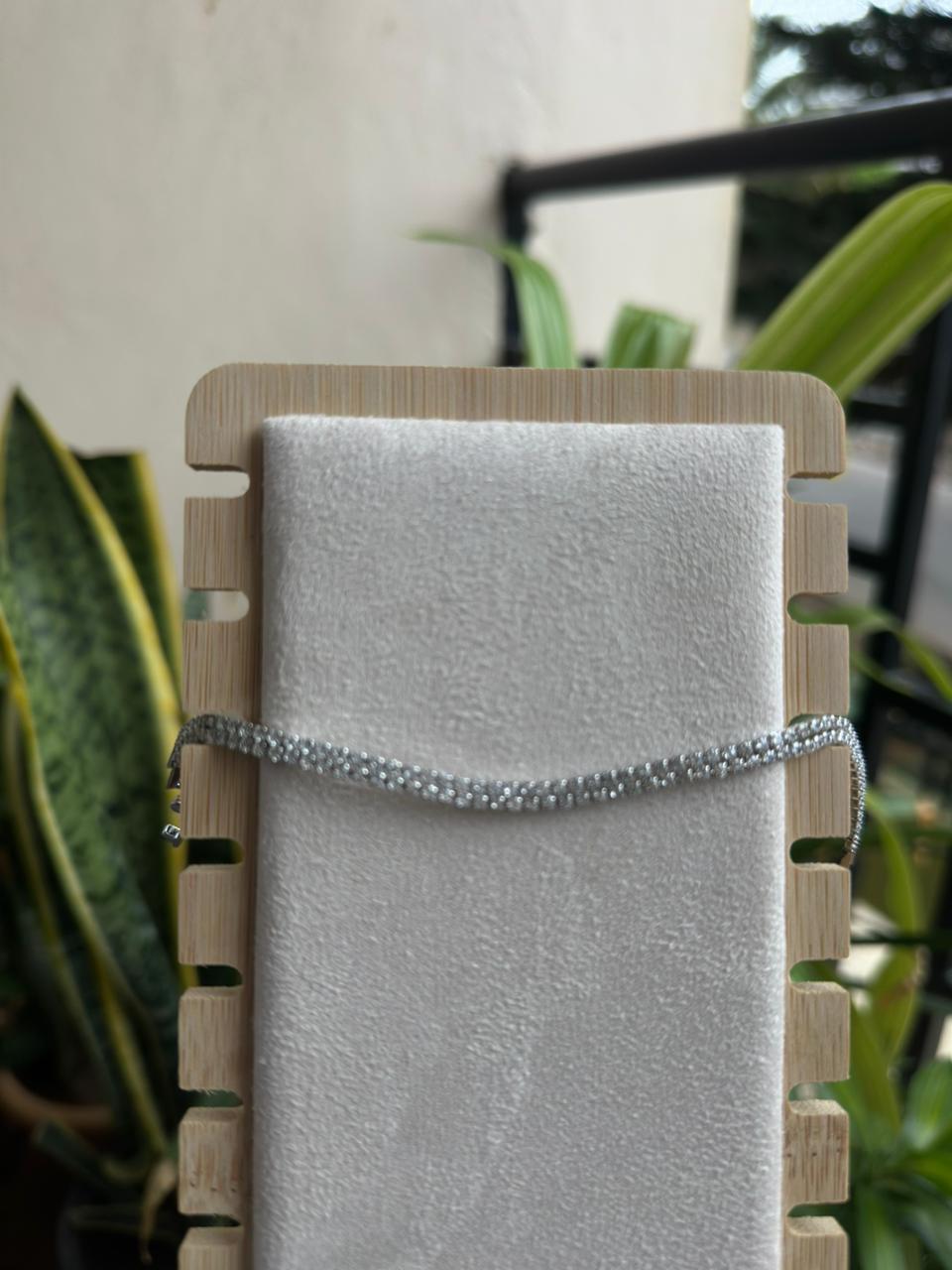 Silver crystal tennis bracelet on white display stand