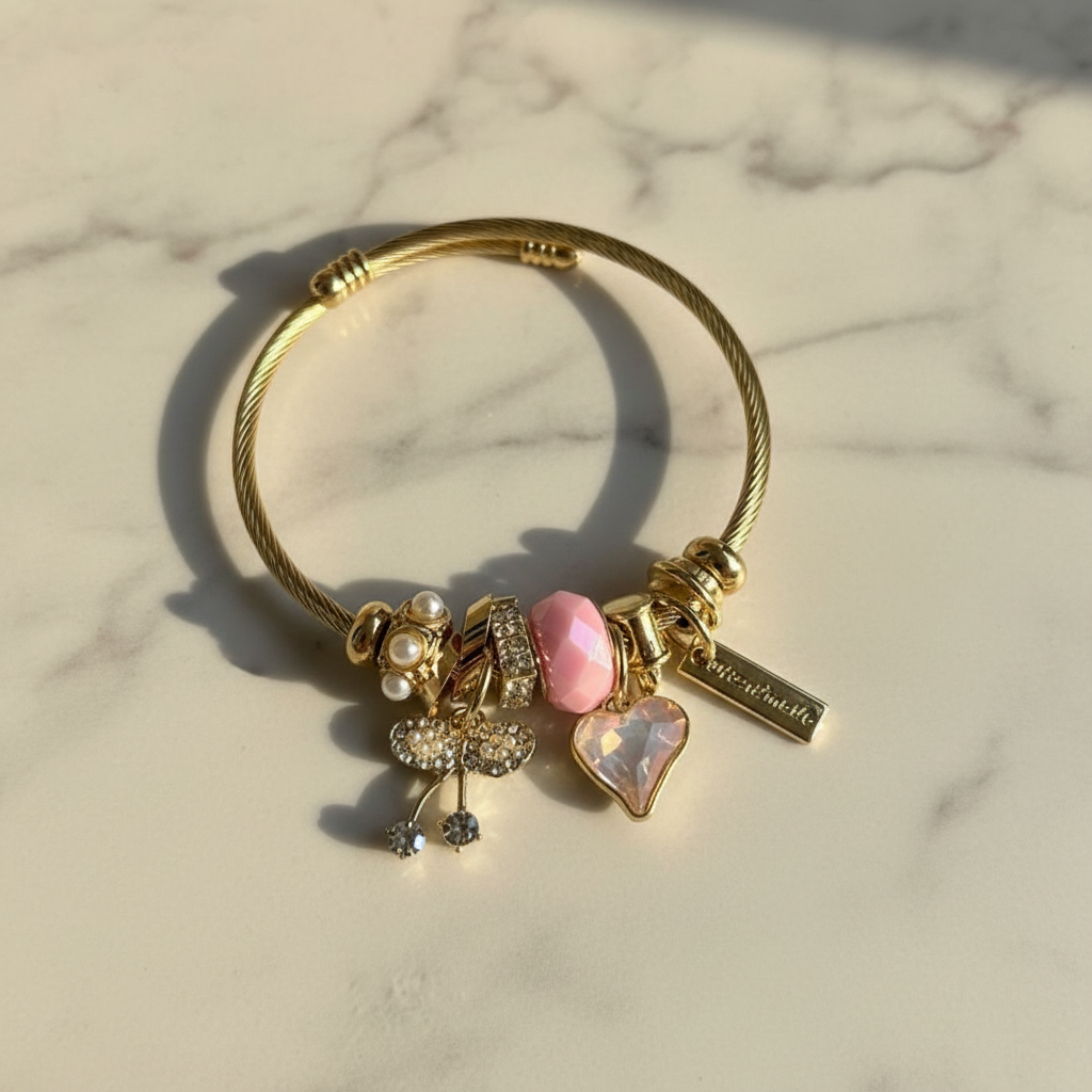 Gold twisted cable charm bangle on white marble surface