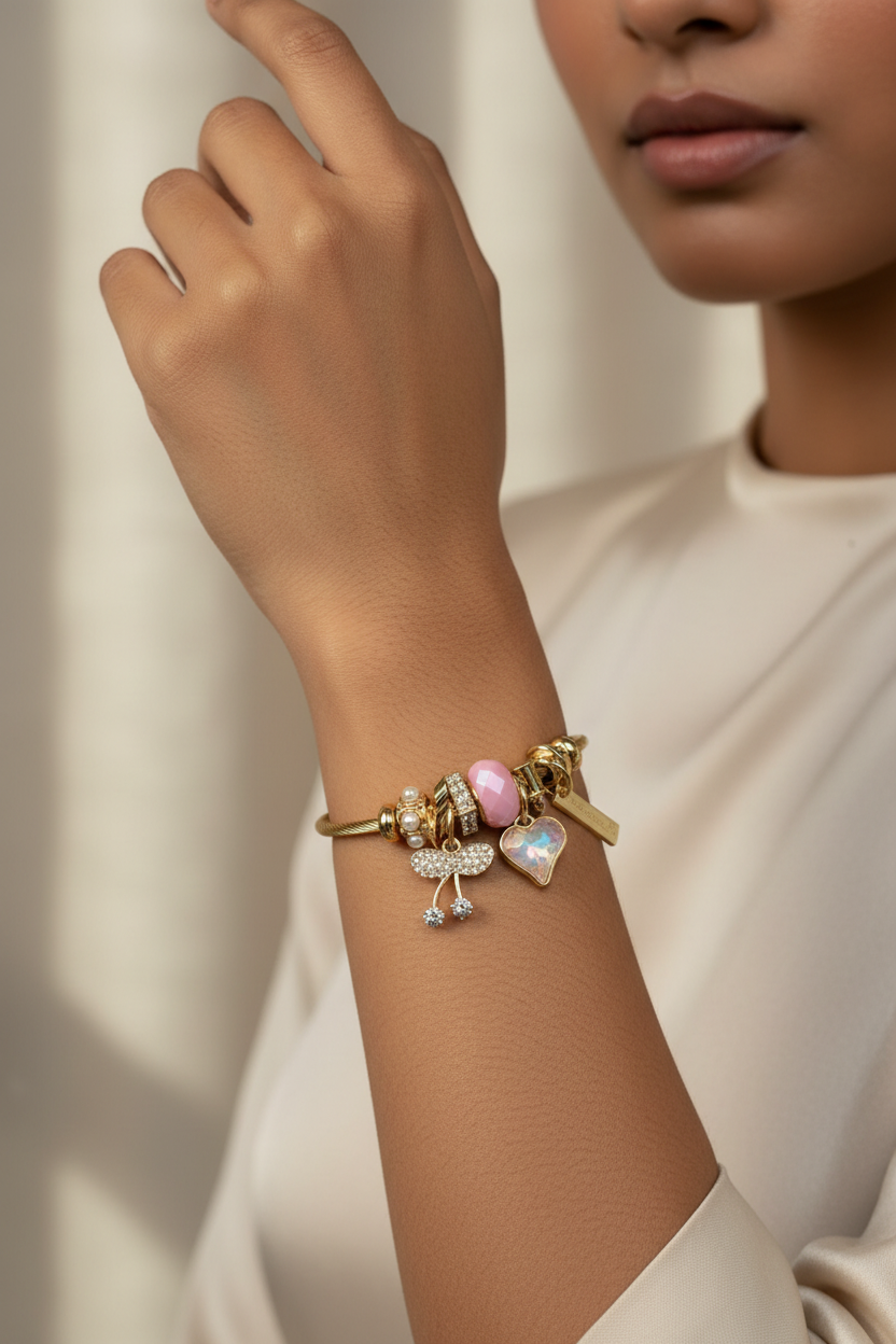Gold twisted cable charm bangle worn on Indian woman's wrist