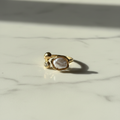 Gold baroque pearl open ring on white marble surface