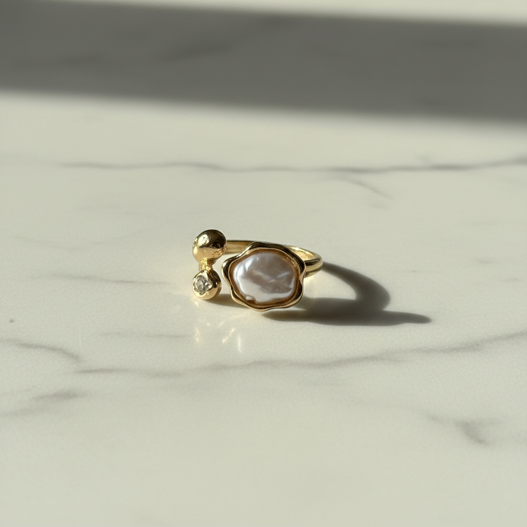 Gold baroque pearl open ring on white marble surface