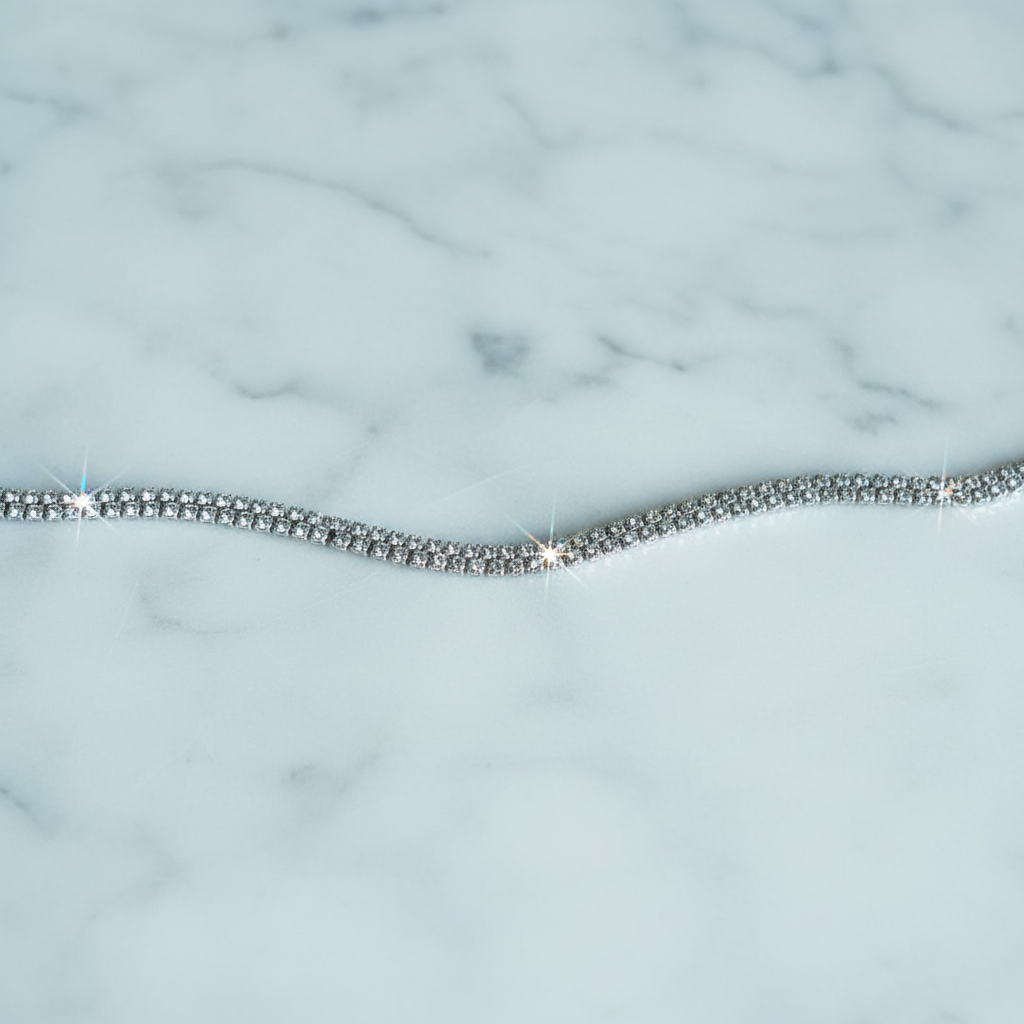 Silver crystal tennis bracelet on white marble surface