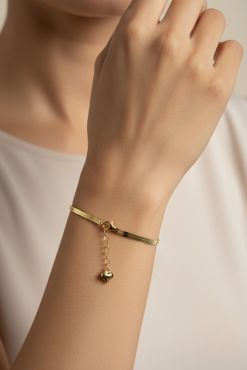 Gold herringbone flat chain bracelet worn on Indian woman's wrist
