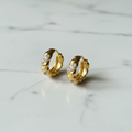 Gold Twisted Rope CZ Huggie Hoops — marble flat lay