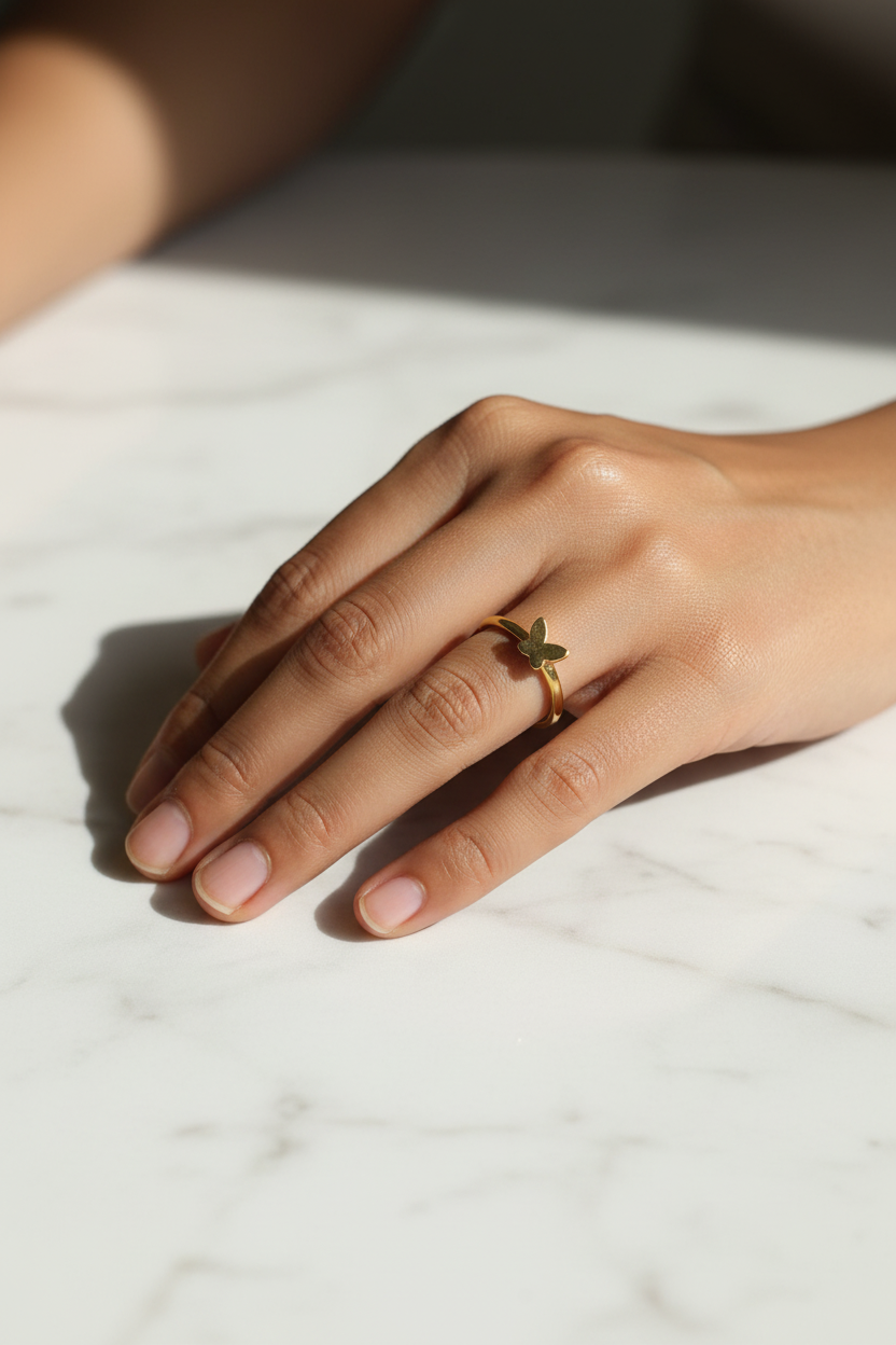 Gold Butterfly Ring — on finger, marble daylight