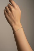 Gold daisy flower and pearl bracelet worn on Indian woman's wrist